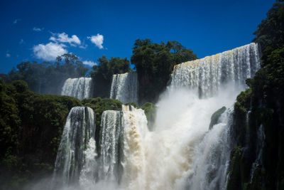 Scenic view of waterfall against sky