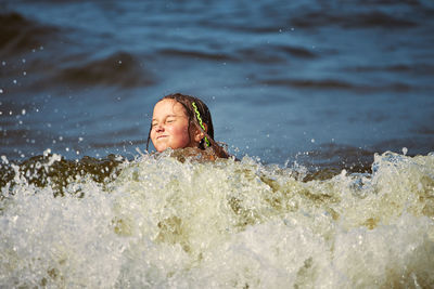 Portrait of young woman swimming in water