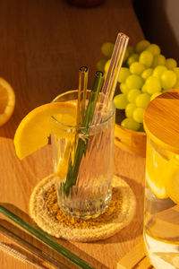 Glass of water with fresh lemon juice with reusable glass straws detox cold tonic water with sunny
