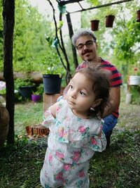 Portrait of happy mother and daughter against plants