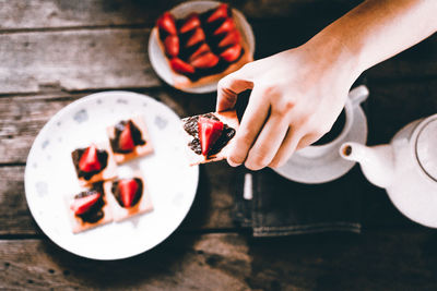 Midsection of woman holding bitscuit on table