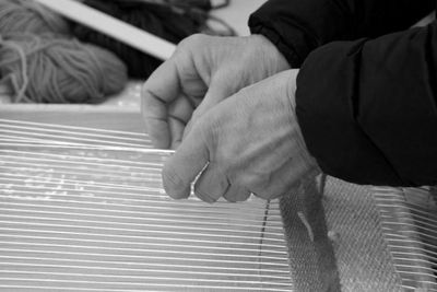 Cropped hands of man holding wool in workshop