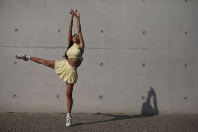 Full length of young woman exercising in gym
