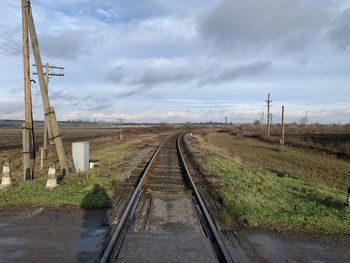Railroad tracks on field against sky