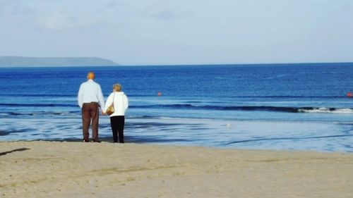 Rear view of man standing on beach