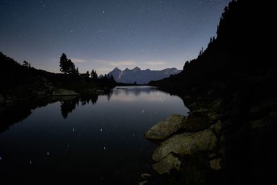 Scenic view of lake against sky at night