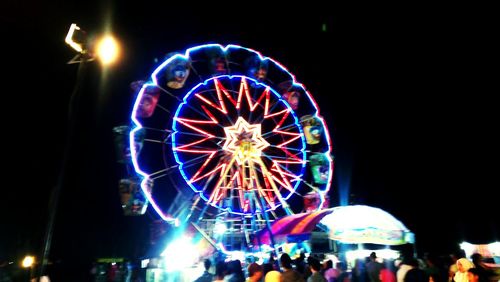 Low angle view of illuminated ferris wheel in amusement park