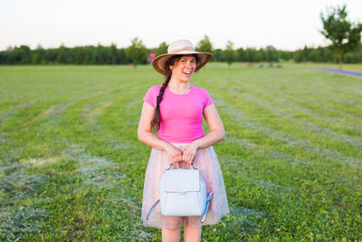 Full length of woman wearing hat standing on field