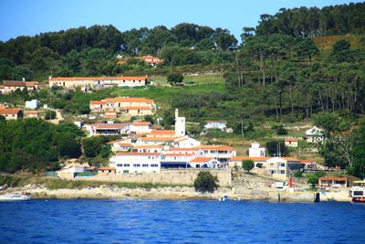 Buildings by river against sky