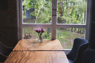 Flower vase on table by window at home