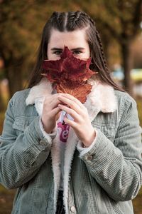 Portrait of young woman holding ice cream standing outdoors