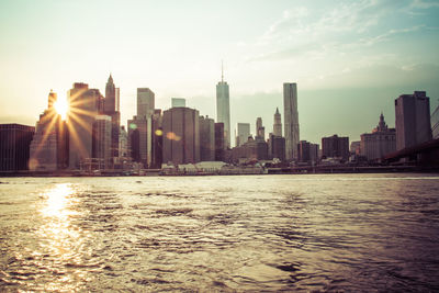 View of city at waterfront during sunset