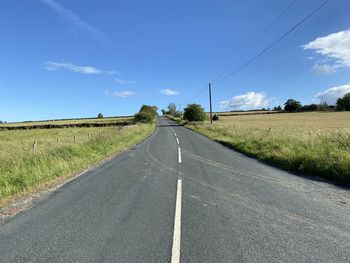 Country road, set against a blue sky in, fewston, harrogate, uk