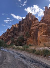 Road by rock formation against sky