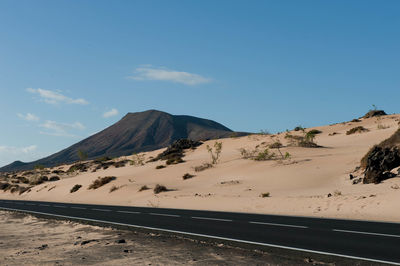 Scenic view of desert against blue sky