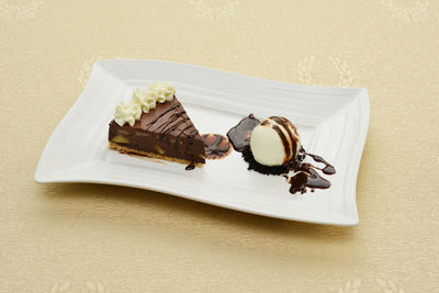 Close-up of chocolate slice with vanilla ice cream served in tray