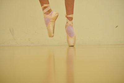 Low section of ballet dancer tiptoeing on floor