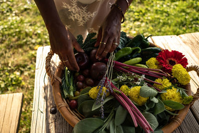 Hand holding vegetables in basket