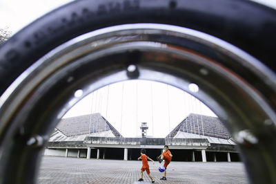 Siblings playing with ball on walkway