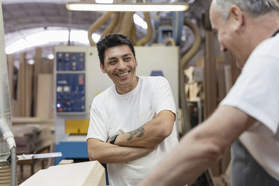 Smiling coworkers working together at workshop