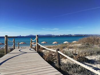 Pier over sea against blue sky