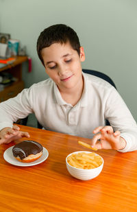 Diet or healthy lifestyle concept. happy boy eating a french fries.