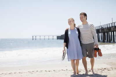 Smiling couple walking on beach