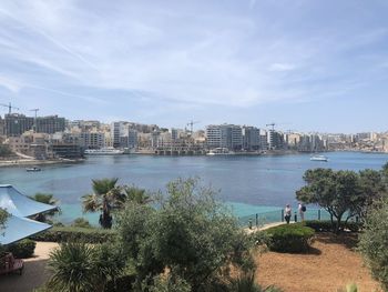 Scenic view of sea by buildings against sky