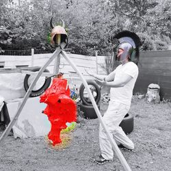 Rear view of woman holding umbrella against plants