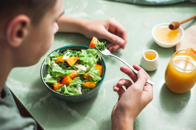 High angle view of boy eating breakfast