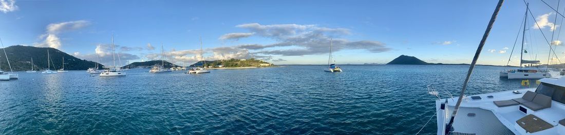 Panoramic view of sailboats in sea against sky