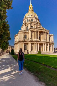 Rear view of woman and building against blue sky