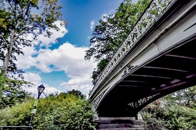 Low angle view of bridge over trees against sky