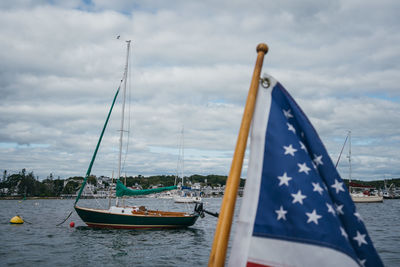 Sailboats in sea against sky