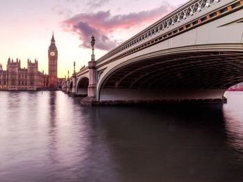 Bridge over river against cloudy sky