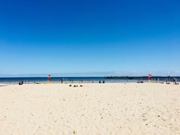 Scenic view of beach against clear blue sky