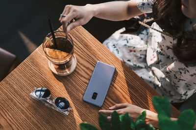 High angle view of woman with coffee on table