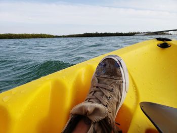 Close-up of yellow boat in sea against sky