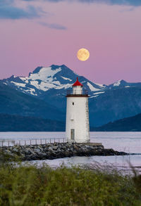 Near full moon over høgsteinen lighthouse, godøy, norway