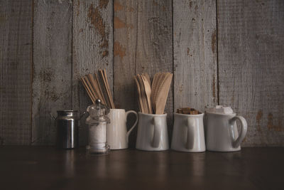 Close-up of glasses on table against wall