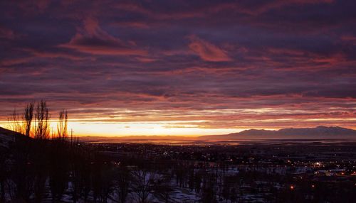 Scenic view of dramatic sky over silhouette landscape