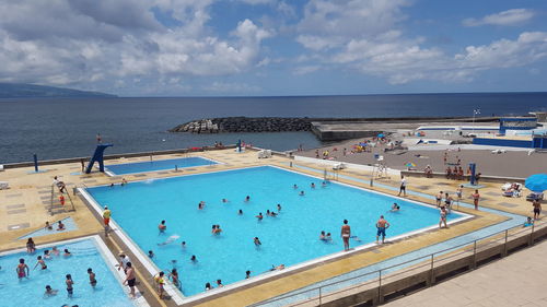 High angle view of people at swimming pool against sky