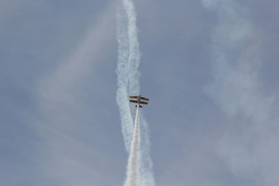 Low angle view of airplane flying against sky