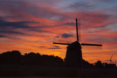 Low angle view of dutch windmill against sky during sunset