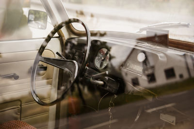 Old german car interior of a eastern trabbi with steering wheel and fire extinguisher in cockpit