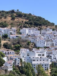 High angle view of whitewashed townscape and buildings against clear blue sky in southern spain.