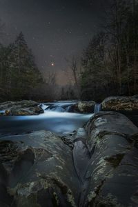 Scenic view of river stream against sky at night