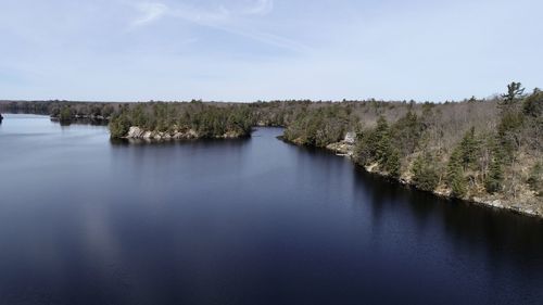 Drone shot of lake shore line and island, calm lake