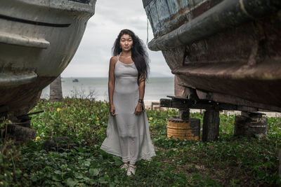 Young woman standing against plants