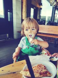 Portrait of boy eating food on table